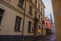 RIGA, LATVIA: Maza Miesnieku iela street. Narrow medieval cobbled street with tenement houses in the old town of Riga. Retro Royalty Free Stock Photo