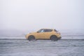 Riga, Latvia - November 15, 2021: Yellow Nissan Juke driving on the foggy autumn morning