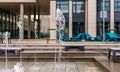 Dancing fountain with office buildings and fancy green benches