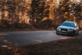 Riga, Latvia 21 October 2021: Front view of Audi A6 3.0 TDI Quattro drifting in the sunny autumn forest, auto in fast motion