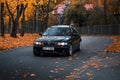 Riga, Latvia-October 6, 2021: Front view of black BMW 330d in the city street during the beautiful autumn