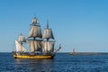 Riga, Latvia, 7.11.2021 - A sailing ship enters the port of Riga, sailing past the MangaÃÂ¼sala pier and the lighthouse of the sea