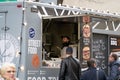 06-03-2020 Riga, Latvia street sale and people concept - happy young saleswoman at food truck serving male customer