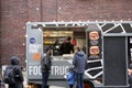 06-03-2020 Riga, Latvia street sale and people concept - happy young saleswoman at food truck serving male customer