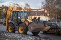 Riga, March 05, 2021: Industrial Tractor. Huge yellow tractor heavy machine service car. Blurred background