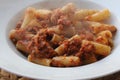 Rigatoni paste with tomato and meat sauce with steam over the plate