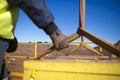 Rigger hand construction worker wearing heavy duty glove holding control a two tones yellow lifting sling