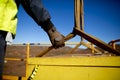 Rigger hand construction worker wearing heavy duty glove holding control a two tones yellow lifting sling