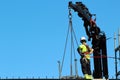 Rigger is helping the crane, keeping right balance and direction Royalty Free Stock Photo
