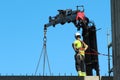 Rigger is helping crane, keeping rigth balance and direction. Royalty Free Stock Photo