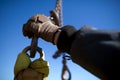 Rigger high risk worker wearing heavy duty glove and clipping a crane hook into lifting lug prior to lift