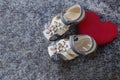 Right baby white and blue orthopedic shoes on a blue background with a red heart. Blue children`s sandals. Copy space Royalty Free Stock Photo