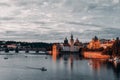 Right bank of Vltava river with Old Town Water Tower and Charles Bridge at dusk Royalty Free Stock Photo