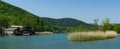 Right bank of Vulcan mountain river in Arkhipo-Osipovka with hotels on green mountains background. Ships and small boats