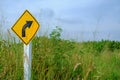 Right bend traffic warning sign on feather grass field Royalty Free Stock Photo