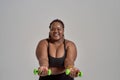 The right direction. Plump, plus size african american woman in sportswear reaching arms forward, holding green