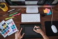 Right equipment. Top view of a designer using graphic tablet and working with computer while sitting at his workplace in Royalty Free Stock Photo