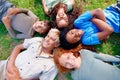 With the right friends, anything is possible. High angle view of a group of children lying on the grass smiling at the Royalty Free Stock Photo