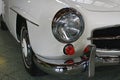 Right front headlight and part of front chrome buffer on german luxury two door roadster Mercedes Benz 190 SL from year 1961