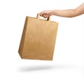 Right hand holding a brown paper bag with handle isolated on white Royalty Free Stock Photo