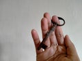 Right hand holding a unique rusty key on a white background