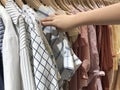 A right hand of a woman who is selecting hanging shirts from Thailand. Royalty Free Stock Photo