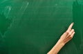 Right hand of a young girl ready to write on the big green school board Royalty Free Stock Photo