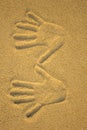 Right and left hand imprint in yellow sand close up Royalty Free Stock Photo
