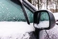 Right rear view mirror and side window of the car covered with snow Royalty Free Stock Photo