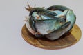 On the right side of the photo: fish caught by a fisherman from the river, lies frozen on a round board and thaws