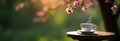 On the right, a small table is set with a teacup and saucer, surrounded by blooming trees with delicate branches Royalty Free Stock Photo
