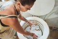 The right temperature gets the right results. a young woman using an electric kiln in a pottery studio.