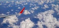 Right wing of jet plane over scattered cloudy sky Royalty Free Stock Photo