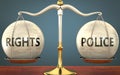 Rights and police staying in balance - pictured as a metal scale with weights and labels rights and police to symbolize balance