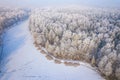 Rime and hoarfrost covering trees. Aerial view of the snow-covered forest and lake from above. Winter scenery. Landscape photo Royalty Free Stock Photo