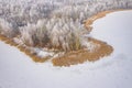 Rime and hoarfrost covering trees. Aerial view of the snow-covered forest and lake from above. Winter scenery. Landscape photo Royalty Free Stock Photo