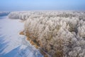 Rime and hoarfrost covering trees. Aerial view of the snow-covered forest and lake from above. Winter scenery. Landscape photo Royalty Free Stock Photo