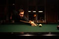 RIMOUSKI, CANADA - Jan 02, 2017: Young Caucasian Man is Aiming his Shot with a Wood Stick on a Pool Green Table Royalty Free Stock Photo