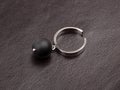 Ring with black baroque pearl on brown leather background