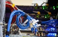 Ring of blue cables on background of blurred server switch with connected connectors, depth of field in blur