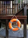 Ring buoy hanging on the wooden staircase near swimming pool in the hotel resort for emergency