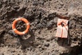 A Ring buoy and life jacket hang on a rock Royalty Free Stock Photo