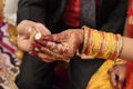 Ring ceremony and the wedding anniversary of the Hindu Indian couple holding gold ring. Royal bangles covering hands with traditio Royalty Free Stock Photo