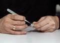 A ring made of silver with zircons in the hands of a jeweler working with it at his workplace Royalty Free Stock Photo