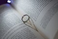 Ring between the pages of a book that projects a shadow in the shape of a heart