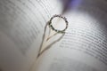 Ring between the pages of a book that projects a shadow in the shape of a heart