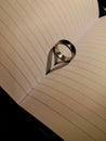 the ring on the paper where the light refracts forms the shadow of a heart Royalty Free Stock Photo
