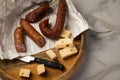 Ring Salami pork sausage with German BierbeiÃÅ¸er and Edamer cheese in wax paper with knife on wooden board background for Brotzeit