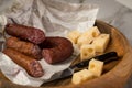 Ring Salami pork sausage with German BierbeiÃÅ¸er and Edamer cheese in wax paper with knife on wooden board background for Brotzeit