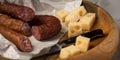 Ring Salami pork sausage with German BierbeiÃÅ¸er and Edamer cheese in wax paper with knife on wooden board background for Brotzeit